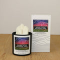 Grand Teton National Park topographic soy candle by Tree Line Candle Co. featuring a 3D mountain design, shown with its coordinating gift box and colorful Grand Teton map artwork.